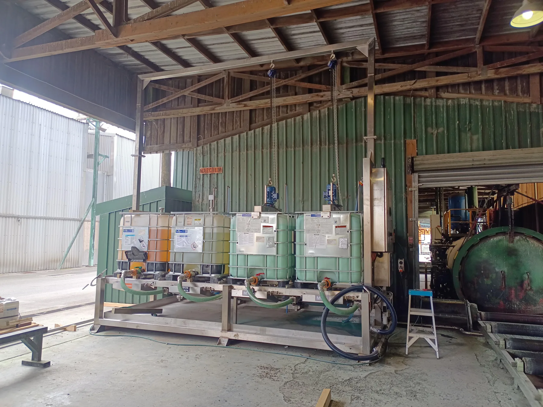 Chemical storage containers, dosing pumps and pipework installed beside a timber treatment plant
